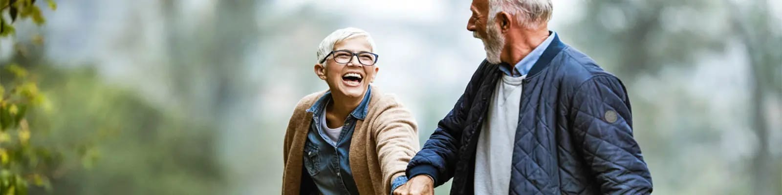 An elderly couple enjoying a walk outdoors.