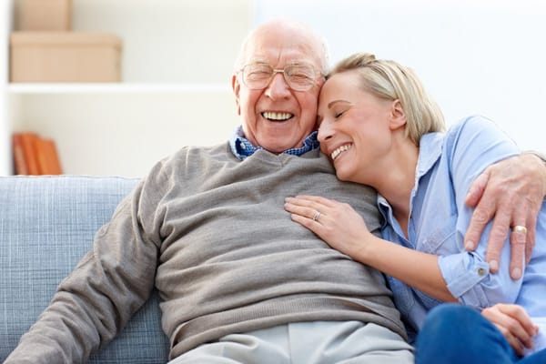 Smiling elderly man sitting with a caregiver