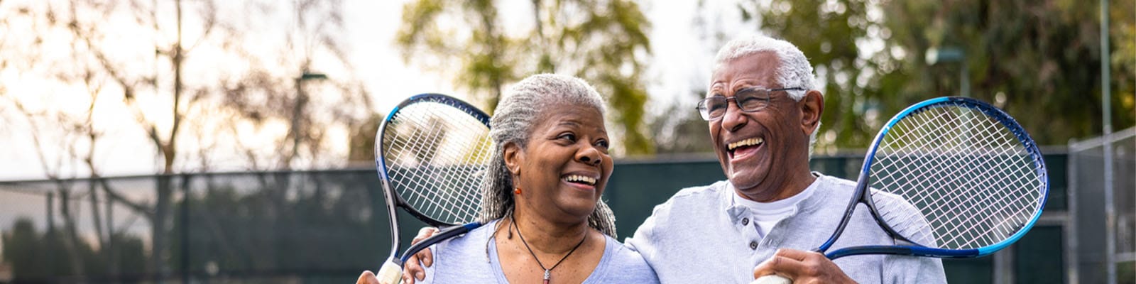 Happy seniors playing tennis outdoors