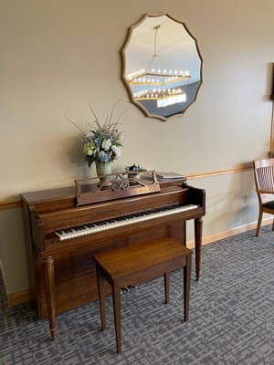 A piano and a decorative vase in a common area