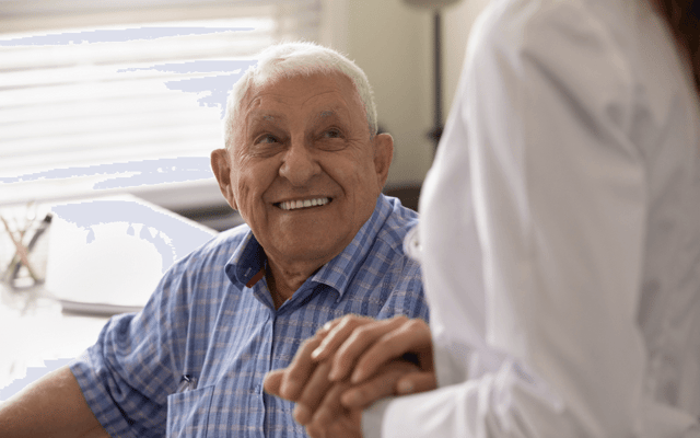 Resident smiling while holding hands with caregiver