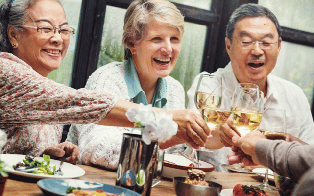 Residents enjoying a toast at a communal meal
