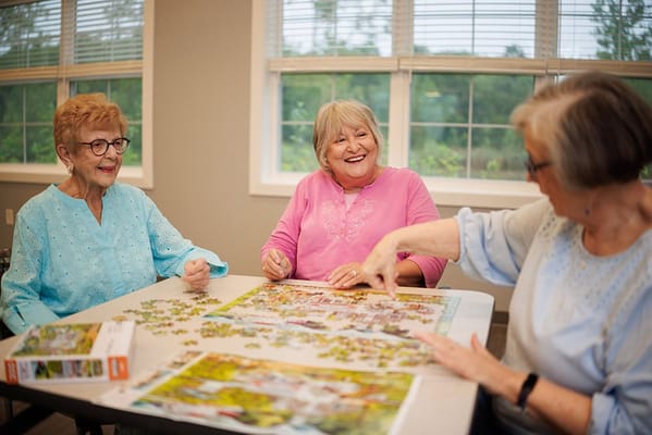 Three residents engaged in a puzzle activity