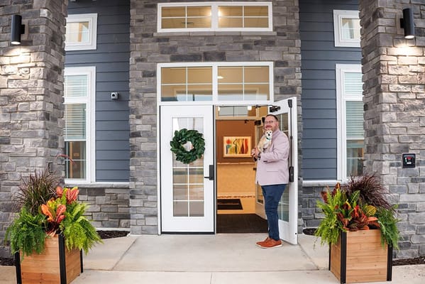 Staff member welcoming visitors at the facility entrance