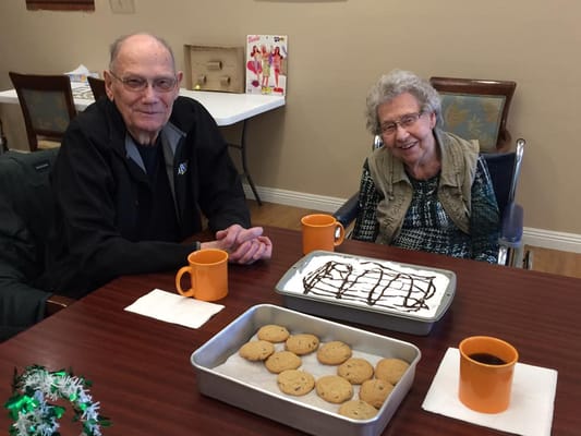Residents enjoying cookies and coffee at a table