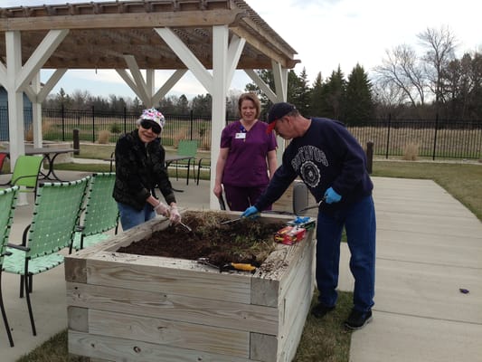 Residents and staff gardening in an outdoor space