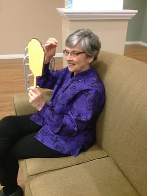 Resident looking at a mirror while seated on a couch