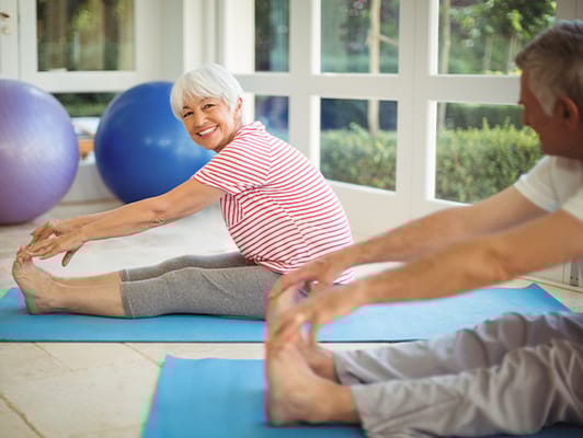 Residents engaging in a stretching exercise in a bright room