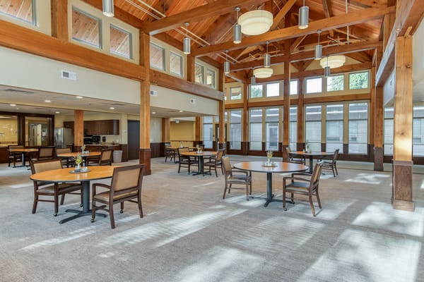 Bright and spacious common area with tables and chairs