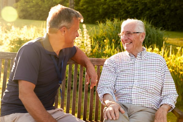 A caregiver and resident enjoying a conversation outdoors
