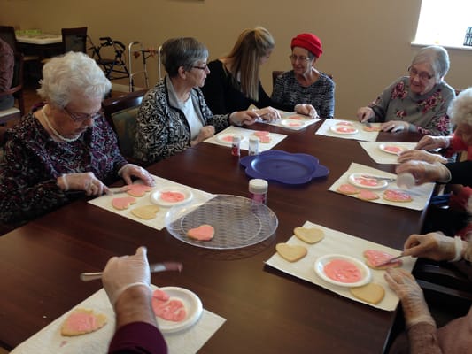 Residents decorating cookies in a communal area