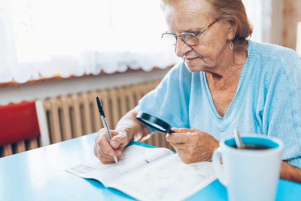 Senior resident working on a crossword puzzle indoors