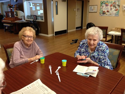 Two residents enjoying activities at a table