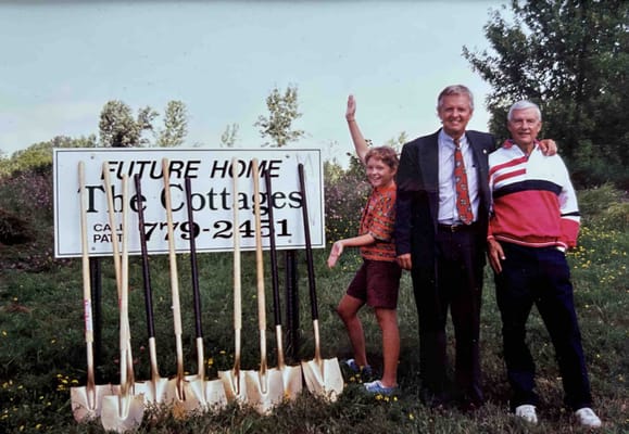 Group of people celebrating near a building sign.