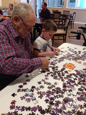Resident and child working on a puzzle together