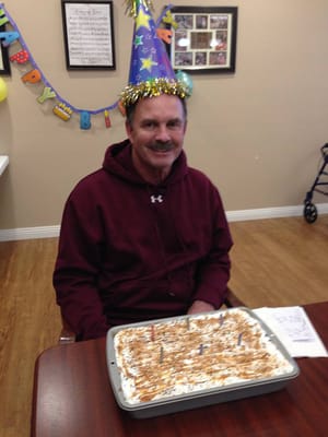 Resident celebrating with a cake at a birthday party