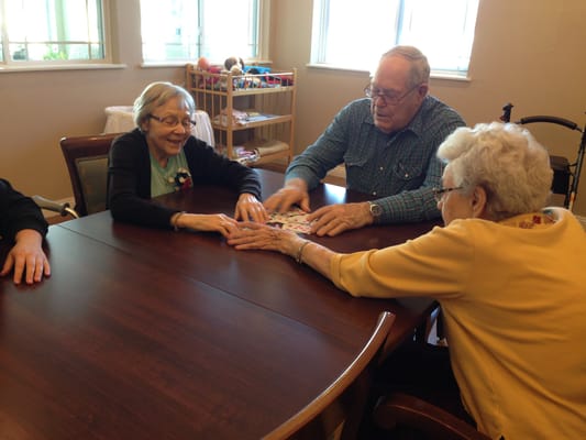Residents engaging in a game at a table