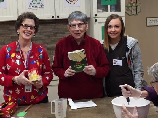 Residents and staff baking in a cheerful kitchen.