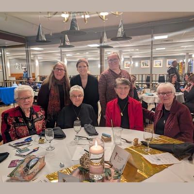 A group of women gathered around a table at an event