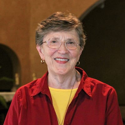 Smiling resident wearing a red shirt in an indoor setting