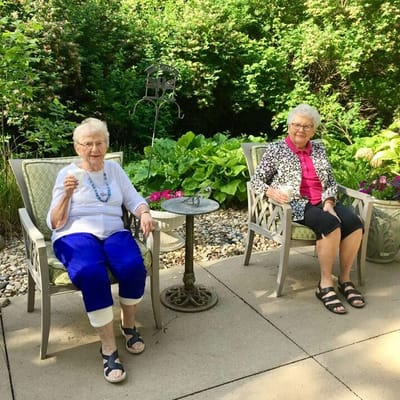 Two residents relaxing in a garden area