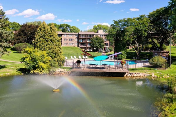 A peaceful outdoor pool area with a fountain and surrounding greenery