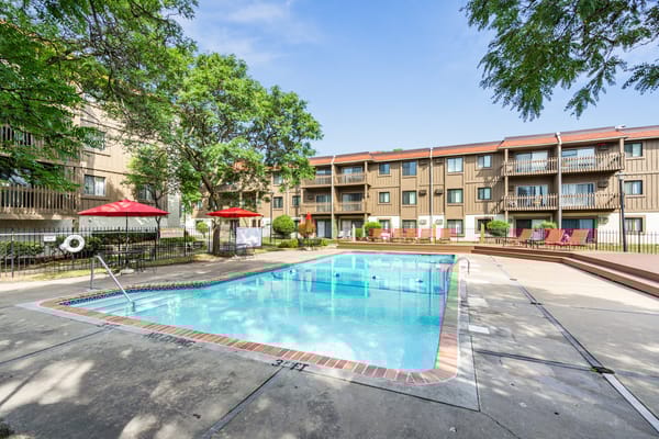 Outdoor swimming pool with lounge chairs in a senior living community