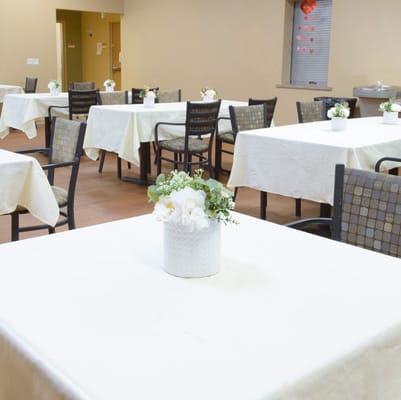 Clean dining area with tables and flower centerpieces