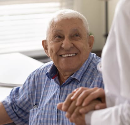 Smiling elderly man conversing with a caregiver