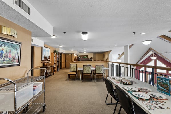 Common area with tables and puzzle activities for residents