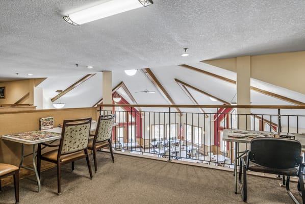 Common area with tables and seating overlooking a dining area