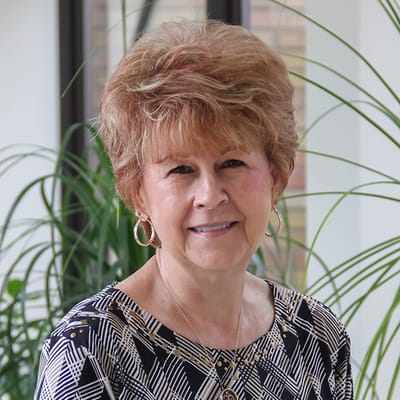 A smiling resident in a well-lit indoor space
