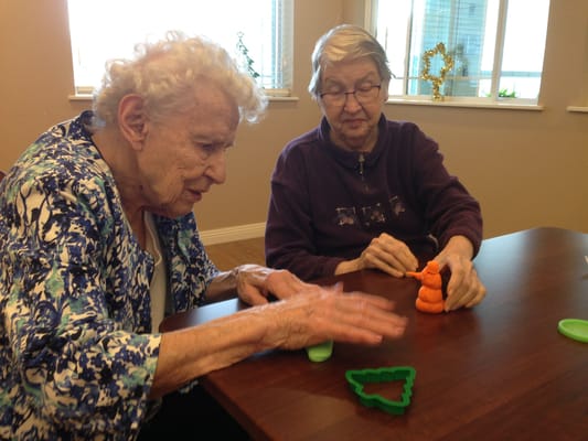 Two residents engaging in a craft activity at a table
