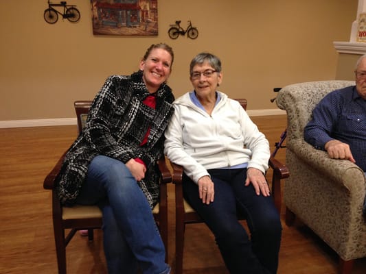 Resident and staff member smiling together in a common area