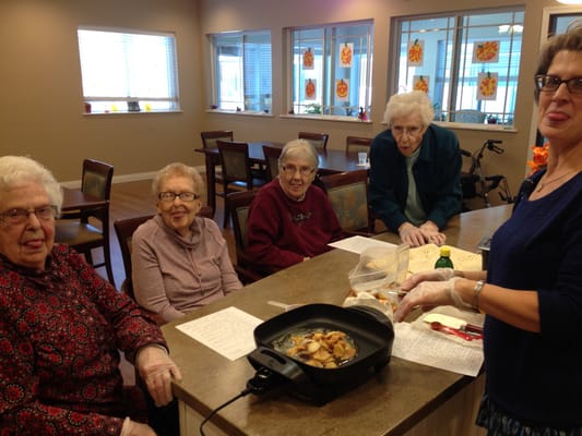 Residents and staff cooking together in a communal kitchen