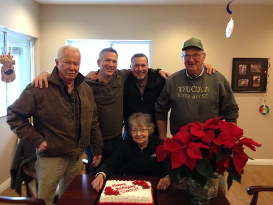 Residents celebrating with a cake and flowers