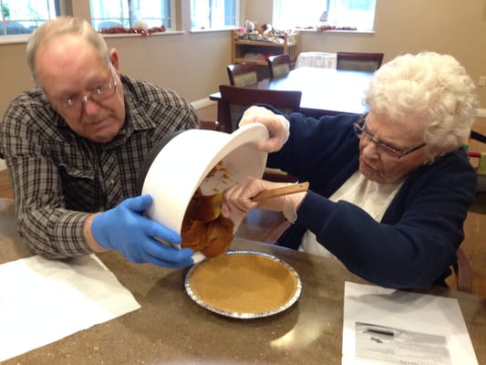 Residents preparing a pumpkin pie in a cozy kitchen