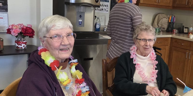 Two residents enjoying a festive activity indoors
