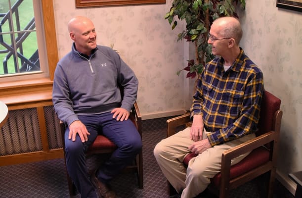 Two residents engaged in conversation in a cozy common area