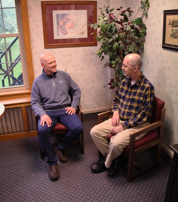 Two gentlemen chatting in a cozy sitting area