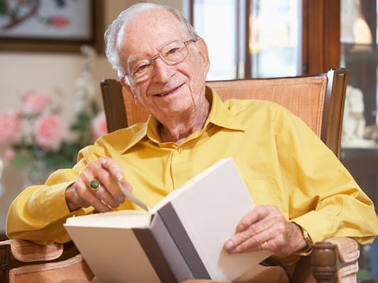 Senior resident reading a book indoors