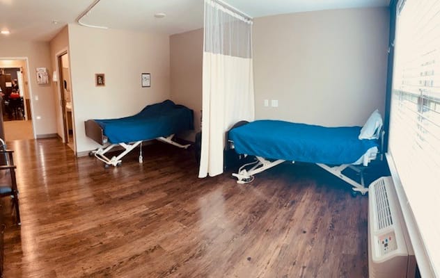 Private resident room with two beds and wooden flooring