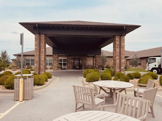 Entrance view of a senior living facility with outdoor seating