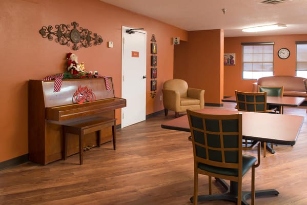 Bright interior common area with a piano and seating