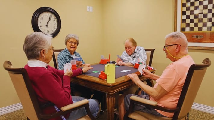 Residents playing cards in a cozy common area