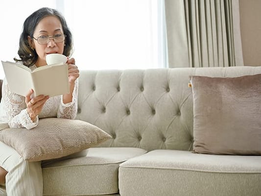 Woman reading a book while sitting on a couch