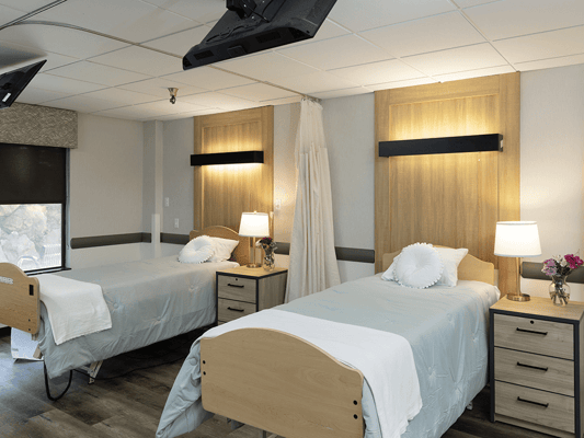 Brightly lit shared resident room with two beds