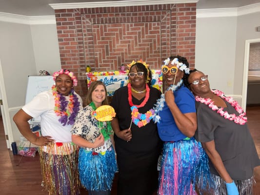 Staff celebrating at a themed event with leis and decorations