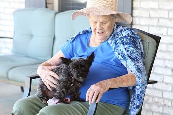 Resident enjoying time with a small dog outdoors