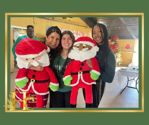 Staff and residents celebrating with Santa figures indoors